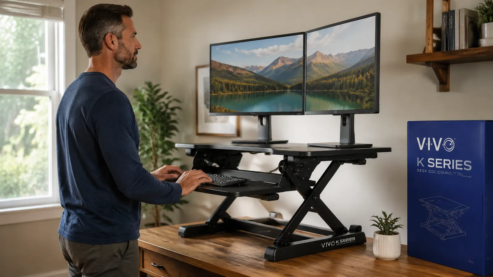 Person standing at a VIVO K Series desk converter while typing, viewed from the side showing the elevated keyboard tray and monitor platform